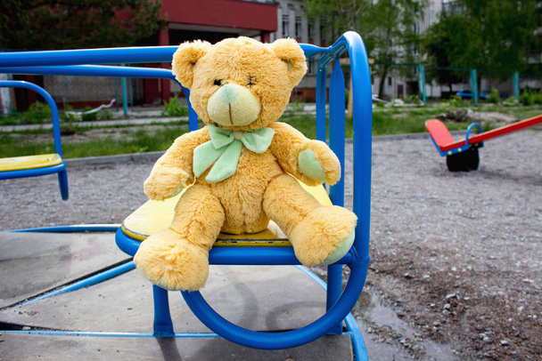 Little bear on the playground. Symbol of a lost childhood - Photo, Image