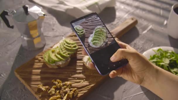 Un concetto di alimentazione sana. Sandwich fotografico a mano con avocado con smartphone
 - Filmati, video