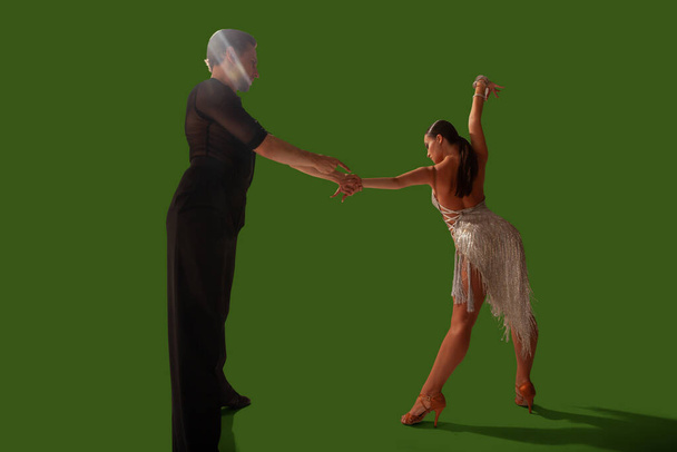 Пара танцюристів виконують латинський танець на зеленому тлі екрану
. - Фото, зображення