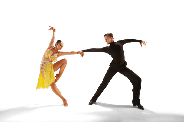 二人のダンサーは白い背景でラテンダンスを行う. - 写真・画像