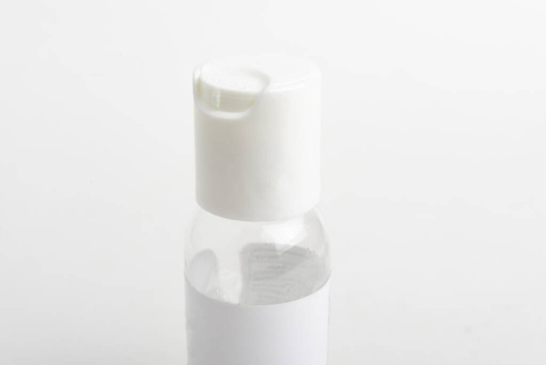 Um close-up produto tiro da tampa branca superior de um bolso transparente mão desinfetante plástico dispensador garrafa definida em um fundo branco liso
. - Foto, Imagem