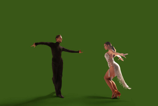 Ζευγάρι χορευτές εκτελούν λατινικούς χορούς σε φόντο οθόνη wgreen. - Φωτογραφία, εικόνα