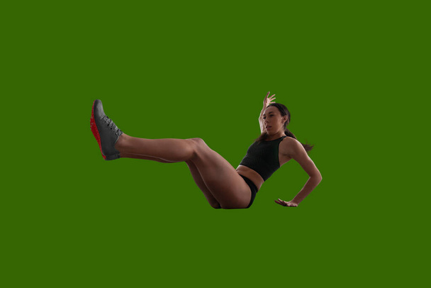 Atleta donna in abiti sportivi su sfondo schermo verde
. - Foto, immagini