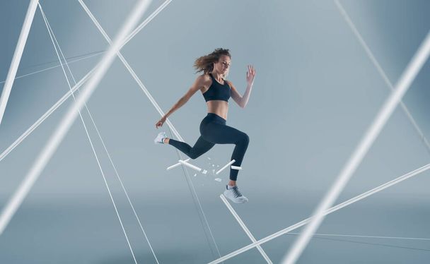 Atleta feminina a correr e a saltar. Vista lateral tiro de wo saudável
 - Foto, Imagem