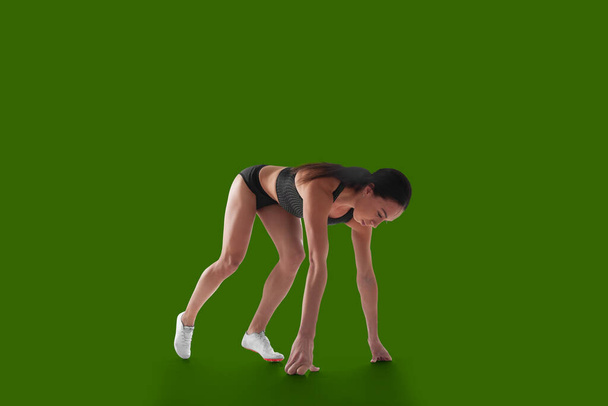 Sportoló nő sport ruhák zöld képernyőn háttér. - Fotó, kép