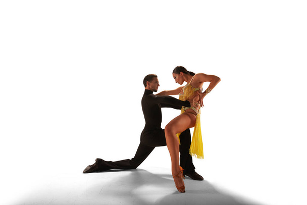 Пара танцоров танцуют латинский танец на белом фоне
. - Фото, изображение