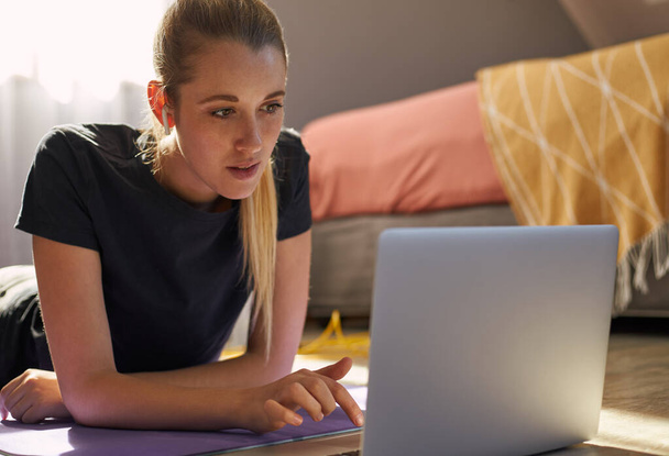 Giovane donna che partecipa a lezione di fitness online davanti al computer portatile. - Foto, immagini