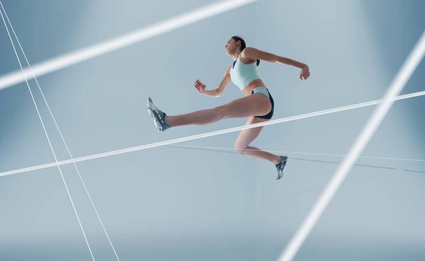 Atleta feminina a correr e a saltar. Vista lateral tiro de wo saudável
 - Foto, Imagem