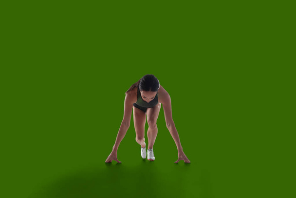 Sportowiec kobieta w ubraniu sportowym na zielonym tle ekranu. - Zdjęcie, obraz