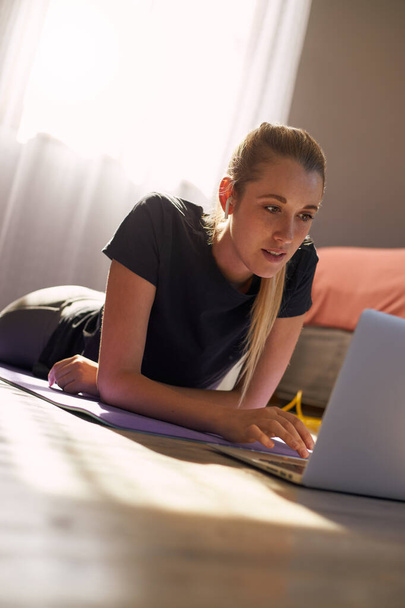Giovane donna che partecipa a lezione di fitness online davanti al computer portatile. - Foto, immagini