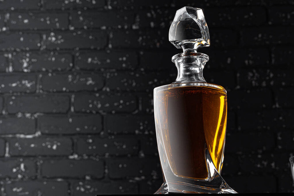 Whisky bottle close up against black grunge wall - Foto, Bild