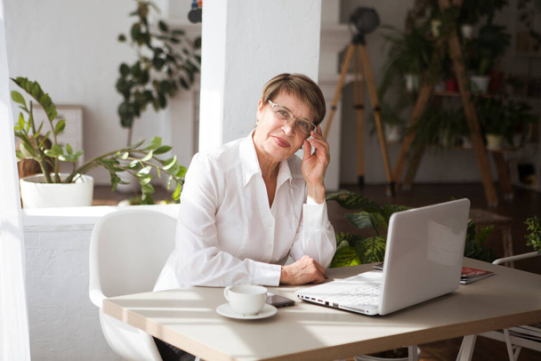 Attractive aged businesswoman working laptop computer indoors.  - Foto, imagen