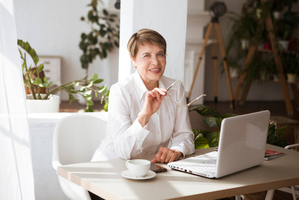 Attractive aged businesswoman working laptop computer indoors.  - Foto, Imagen