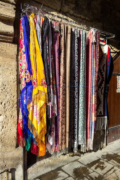 Foulards de différentes nations et nationalités de tous les temps sont à vendre dans la vieille ville sur de vieilles pierres
 - Photo, image