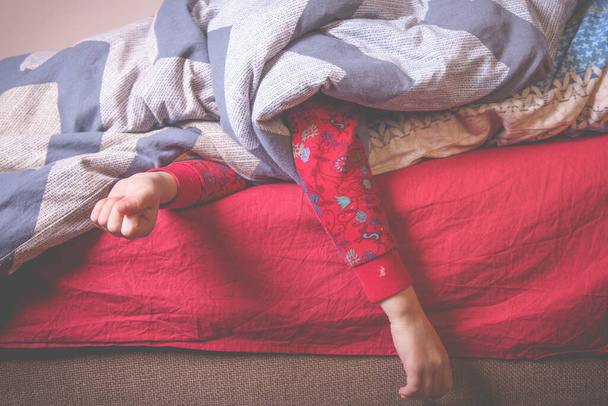 Slaap van een schattig jong meisje. Het kind slaapt onder een deken. Zorgeloos en gelukkig kinderconcept - Foto, afbeelding