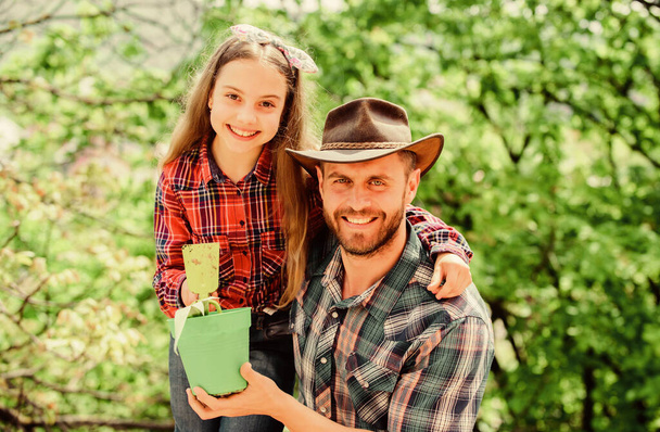 Family dad and daughter planting plants. Plant your favorite veggies. Planting season. Family garden. Transplanting vegetables from nursery or gardening center. Maintain garden. Planting flowers - Foto, Imagen