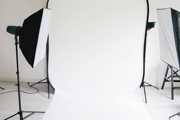 white professional photo studio room with light interior for shooting models with modern soft box flash equipment - Photo, Image