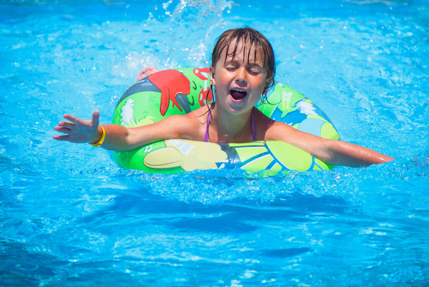 Bella bambina in piscina rilassarsi nuotare sull'anello gonfiabile. Vacanze estive, vacanze e infanzia felice
. - Foto, immagini