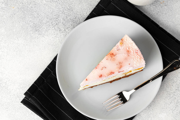 Piece of cheese cake on white plate on table - Φωτογραφία, εικόνα