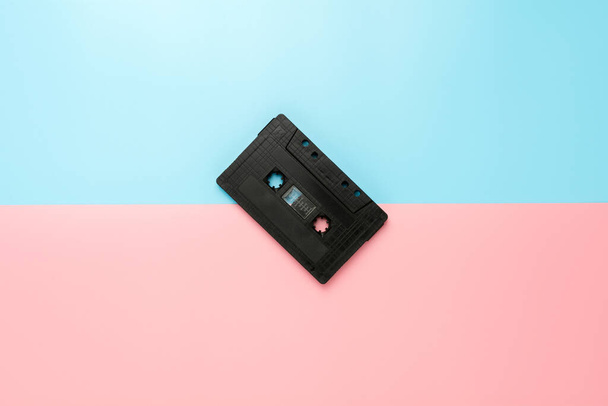 zwarte tape cassette op blauwe en roze achtergrond. - Foto, afbeelding