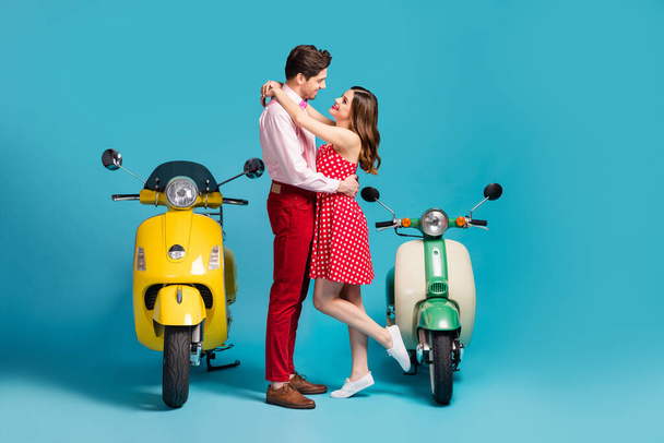 Portrait of his he her she nice attractive cheerful affectionate couple wearing retro look outfit hugging near rental moped isolated over bright vivid shine vibrant blue color background - Foto, Bild