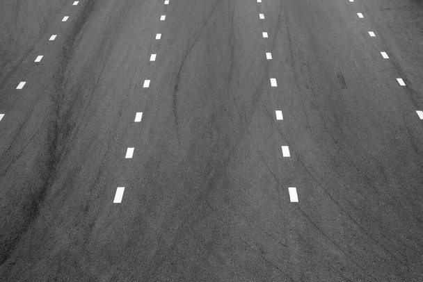 witte verflijn op zwart asfalt. achtergrond ruimtevaart - Foto, afbeelding
