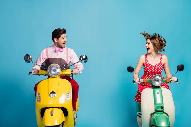 Funky amazed wife husband crazy bikers rider driver drive electric scooter chopper enjoy wind air blow redhair brown hair wear red dotted skirt shirt isolated over blue color background - Fotó, kép