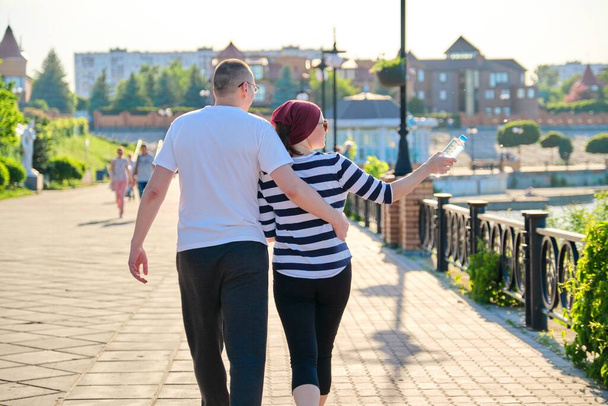 Mature couple hugging walk along the promenade in the park - 写真・画像