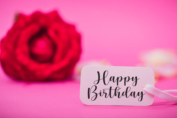 Születésnapi háttér virágokkal és kártyával. Rózsa és boldog szülinapot a fehér kártyán. Pasztell színek szelektív fókusz kép. - Fotó, kép