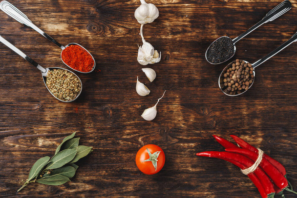 Spices in spoons on dark wooden background top view - Fotó, kép