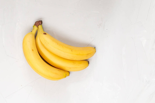 Bündel frischer süßer Bio-Bananen auf weißem Hintergrund, leerer Raum für Text - Foto, Bild