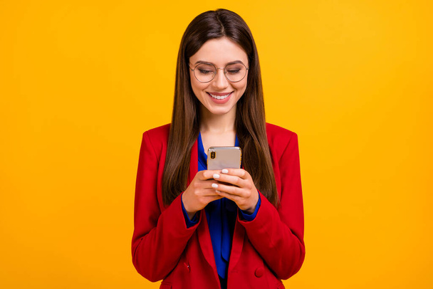 Portrait of positive cheerful girl ceo blogger worker use smartphone read follow share social network news typing wear red suit blazer jacket isolated over shine bright color background - Foto, Imagen