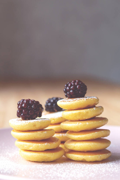 Close up of tiny pancakes with blackberries. - 写真・画像