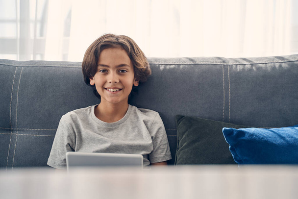 Happy Caucasian boy sitting and laughing in living room - Foto, Bild