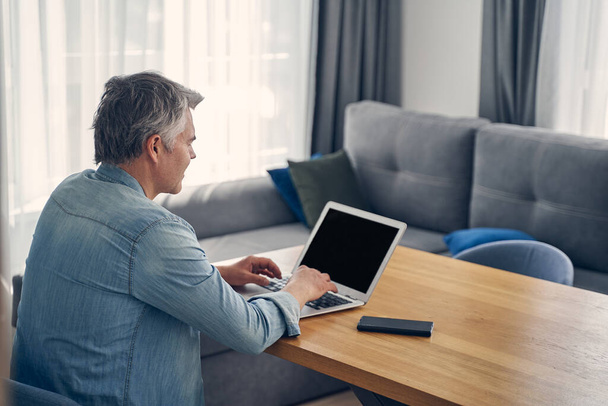 Grey-haired male staying at home with computer - Photo, image