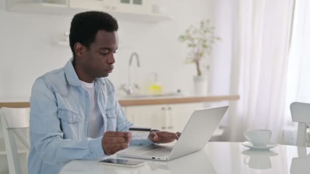 自宅でアフリカ人男性によるノートパソコンでのオンラインショッピング - 映像、動画