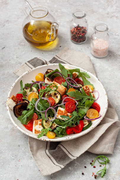 Свежий овощной салат с рукколой, овощами на гриле, помидорами хереса и сыром галлуми.
 - Фото, изображение