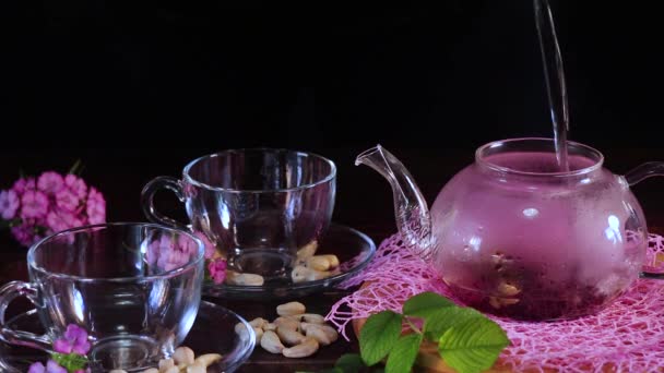 Ρίξτε βραστό νερό σε μια τσαγιέρα με φύλλα τσαγιού. Κόκκινο ζεστό τσάι ιβίσκου σε γυάλινη κούπα. Tea time: cup of tea, carcade, karkade, rooibos. ανατολίτικο, ζεστό, τελετή, παράδοση, γιαπωνέζα, φυλλωσιά, ύγκε - Πλάνα, βίντεο