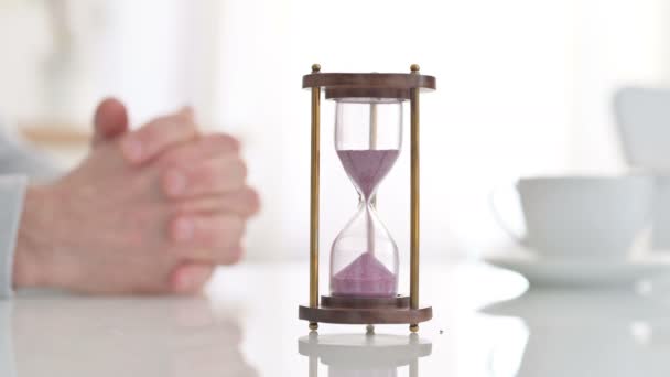 Hourglass on a Table Near Hands of a Man Waiting Impatiently  - Footage, Video