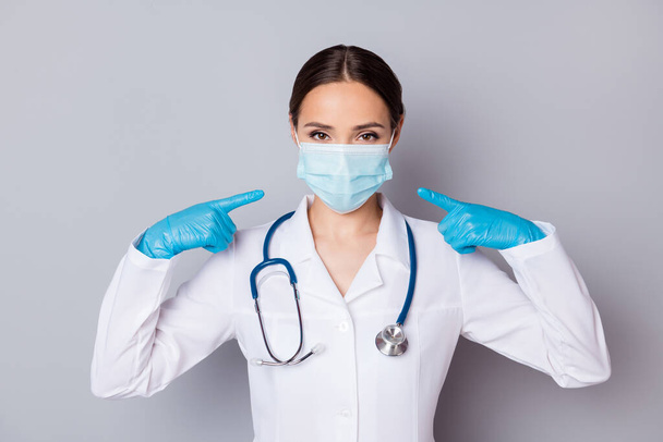 Photo of virologist doc lady experienced professional direct fingers her face advising facial cotton mask good quality wear medical uniform lab coat stethoscope isolated grey background - Foto, imagen