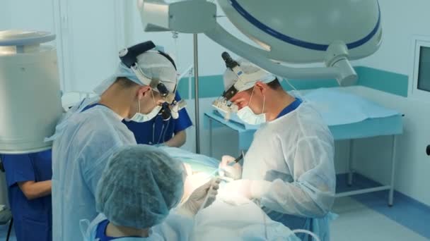 cirurgiões realizar uma operação e olhar através de um microscópio móvel - Filmagem, Vídeo