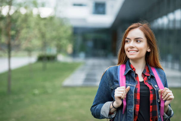 Portret van een mooie studente op campus gebouw achtergrond - Foto, afbeelding
