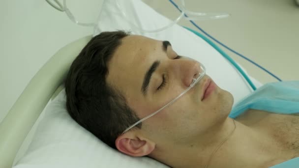 close-up van een patiënt op de intensive care met een zuurstofbuis in zijn neus - Video
