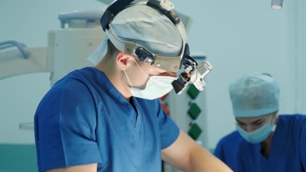 cirurgião olha através de um microscópio móvel e realiza uma operação - Filmagem, Vídeo
