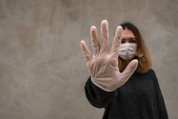 Portrait of woman with face mask and gloves says stay at home - Valokuva, kuva