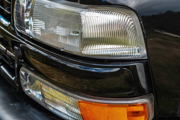 detailfoto van de bestuurderszijde van een SUV met koplampen, meters en grille - Foto, afbeelding