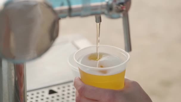 garçom derrama cerveja em um copo de plástico - Filmagem, Vídeo