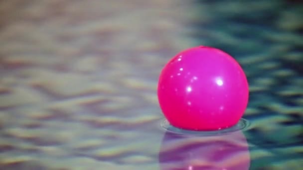 punainen muovi pallo huojuu valon aallot altaassa - Materiaali, video
