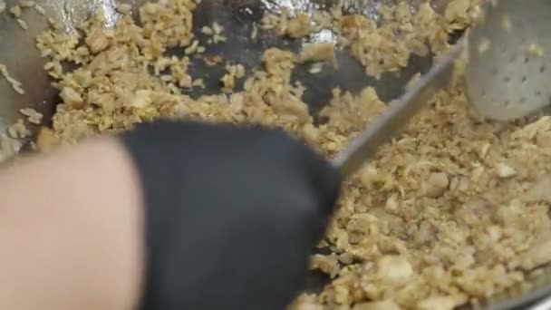 ένα πιάτο ρύζι και κρέας μαγειρεύεται σε ένα τηγάνι - Πλάνα, βίντεο