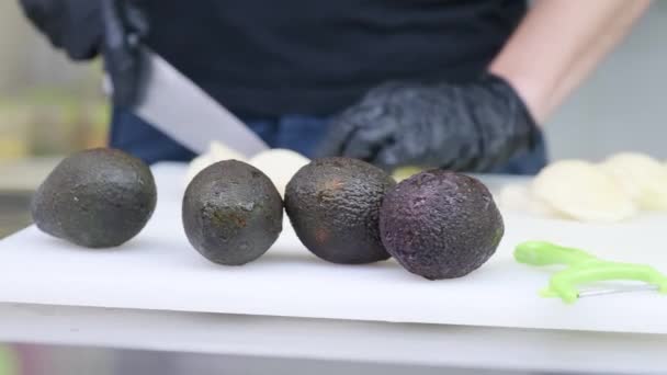 Koch schneidet Avocado auf den Tisch - Filmmaterial, Video